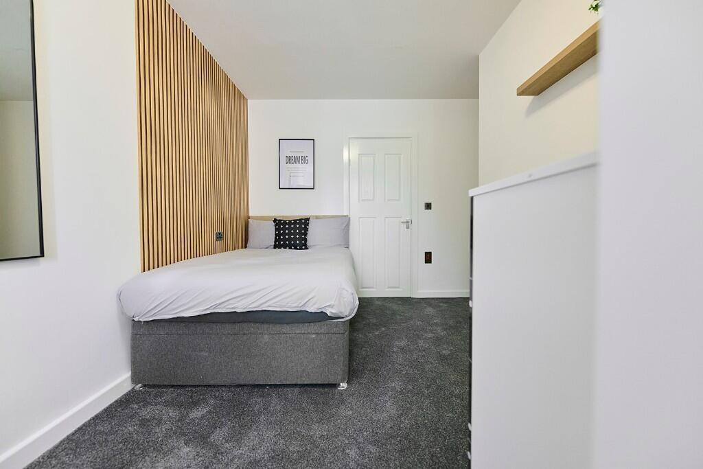 A neat and modern single bedroom with a comfort...