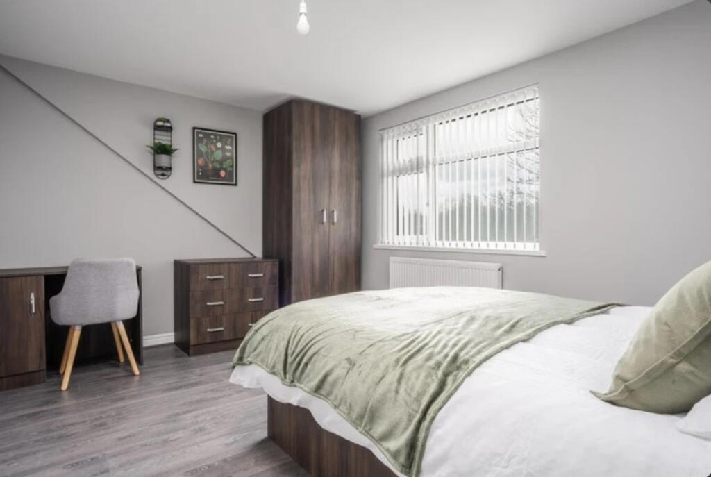 This inviting double bedroom features a cozy be...