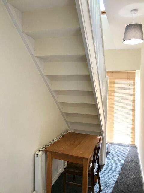 Bright hallway featuring a wooden table and cha...