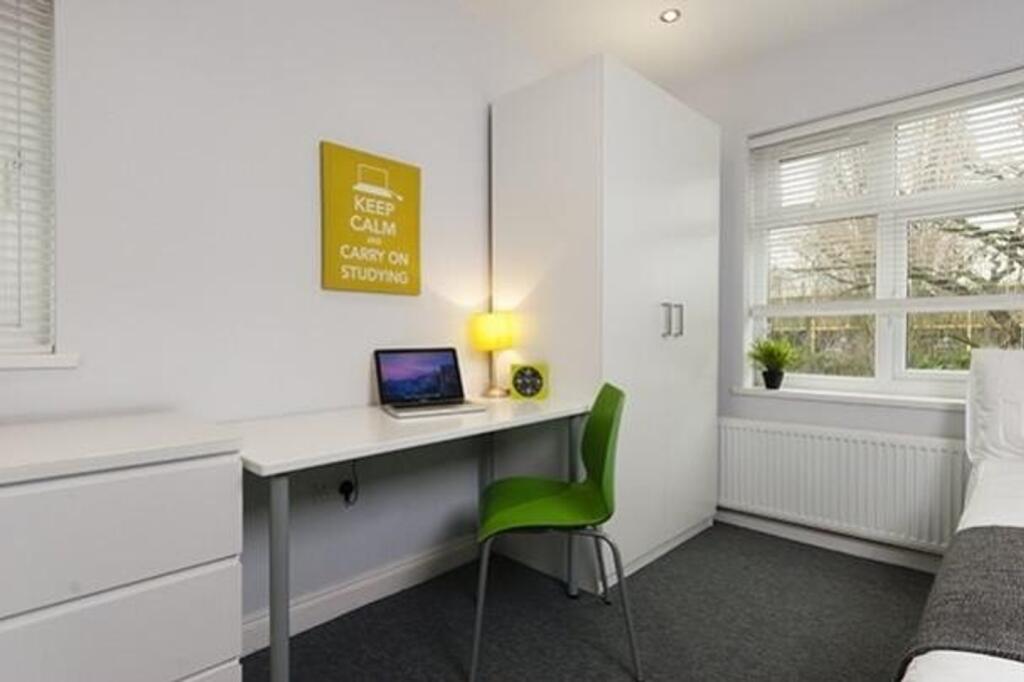A bright and inviting double bedroom with a stu...