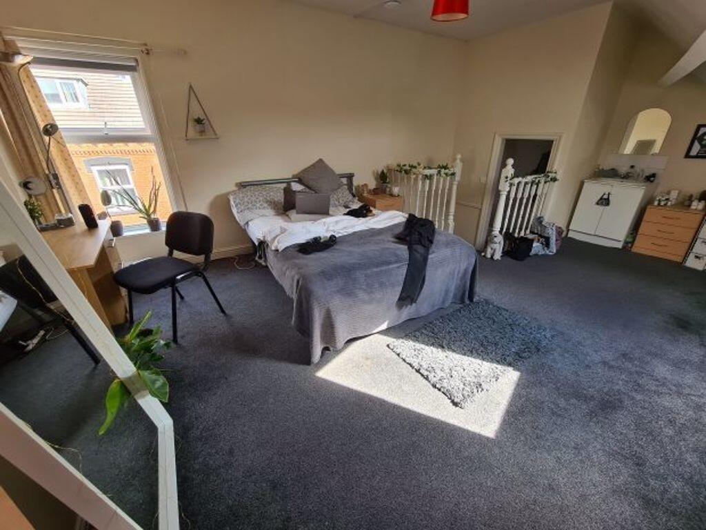 Spacious master bedroom featuring a large bed, ...