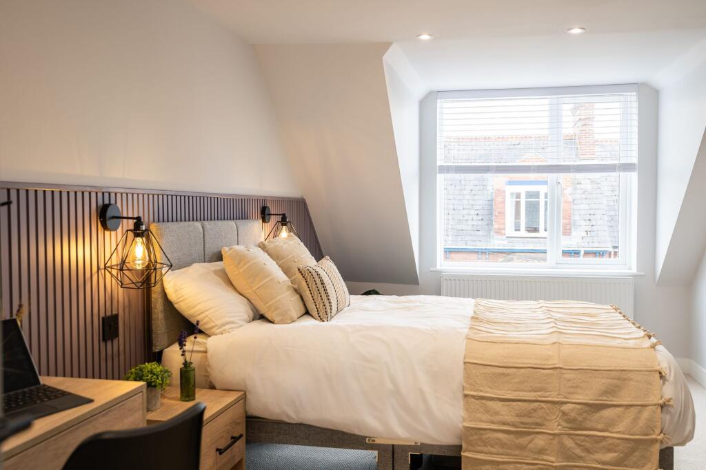 A bright and stylish bedroom featuring a comfor...