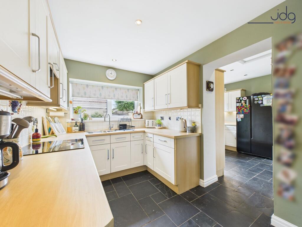 Kitchen flowing openly into a matching utility room