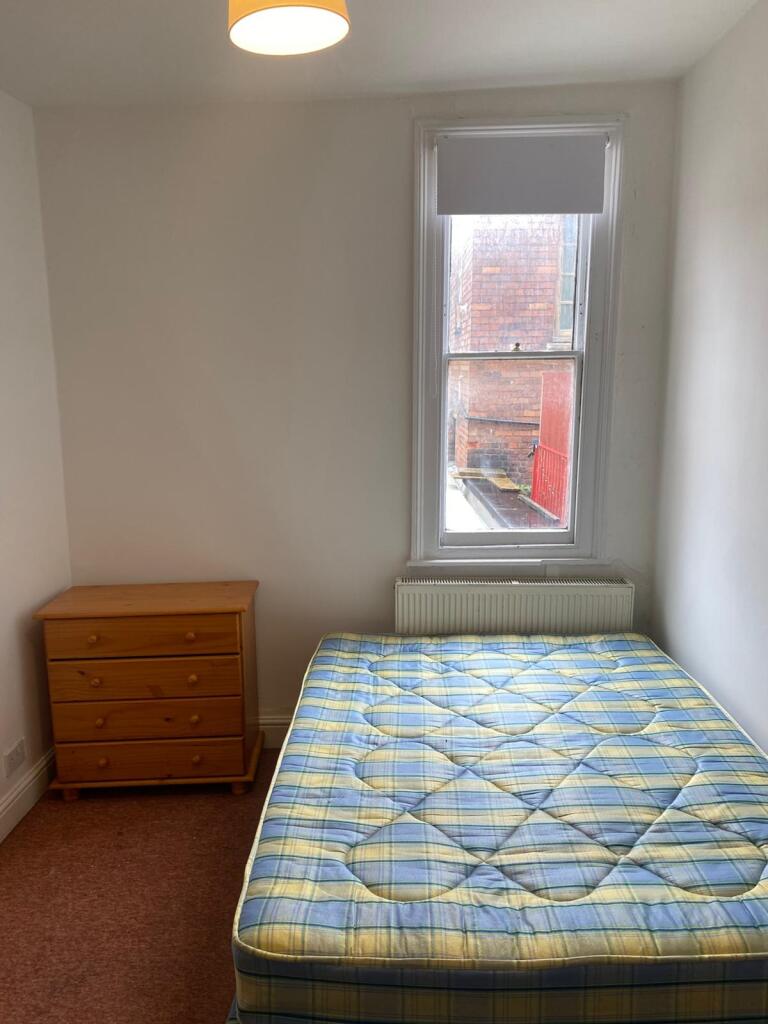 A cozy double bedroom featuring a large window ...