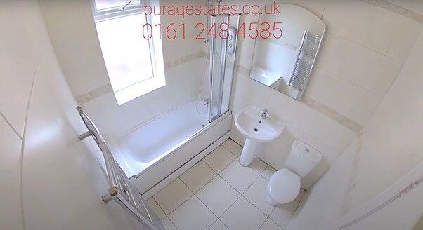 Bright, modern bathroom with a fitted bathtub a...