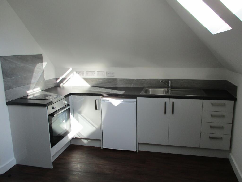 Modern kitchen area featuring a sleek black cou...