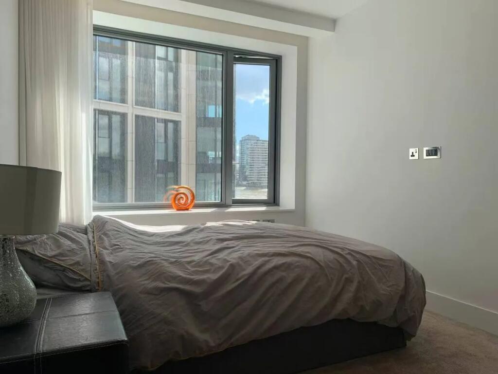 A bright double bedroom featuring a large windo...