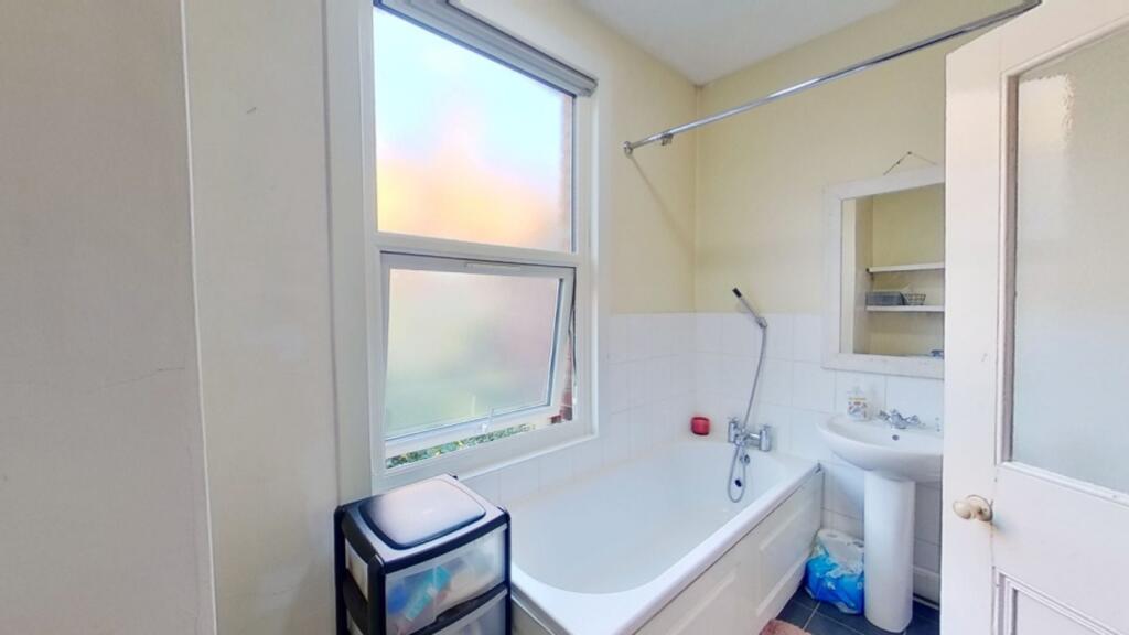 A bright and tidy bathroom featuring a bathtub ...