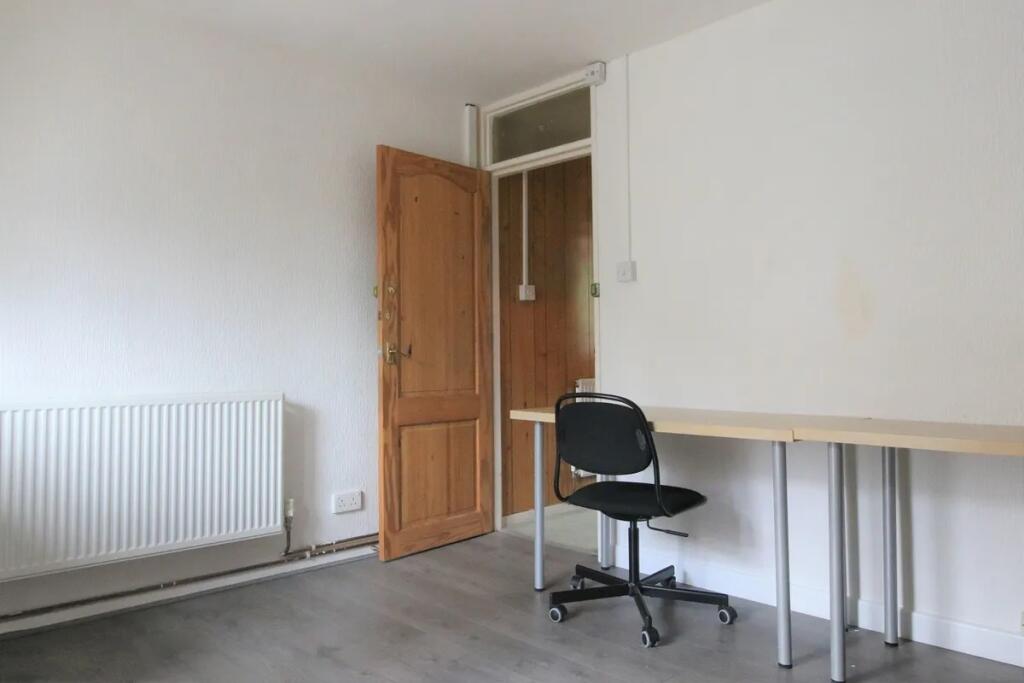 A simple communal workspace featuring a long de...