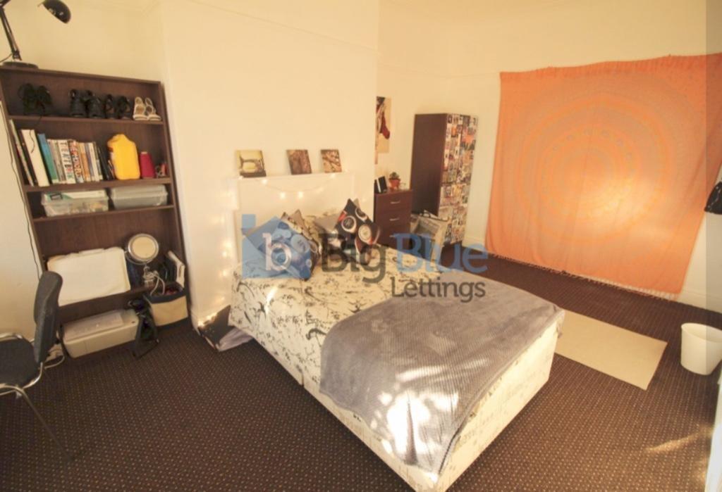 Cozy single bedroom featuring a comfortable bed...
