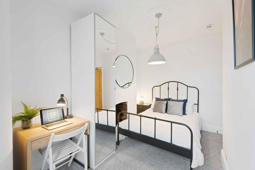 A bright and stylish double bedroom featuring a...