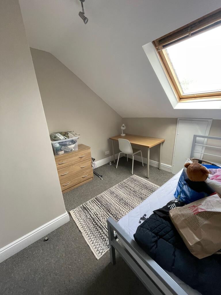 A cozy student bedroom featuring a single bed, ...