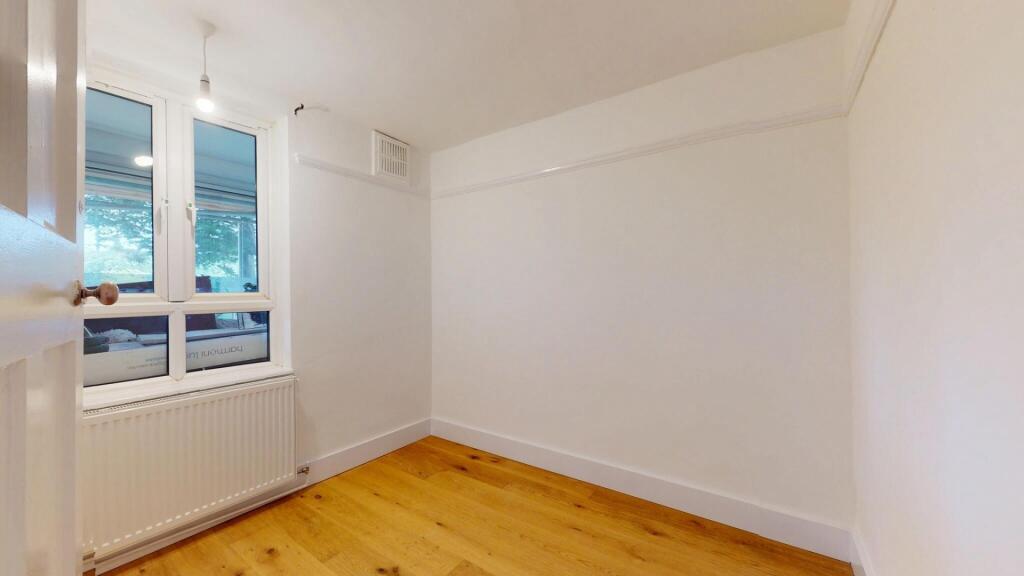A bright and clean bedroom with a large window ...