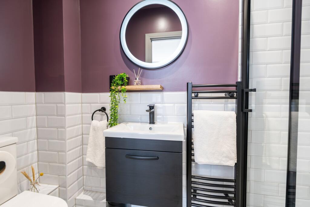 A modern bathroom featuring stylish white subwa...