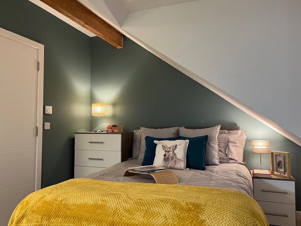 A cozy and stylish double bedroom with warm lig...