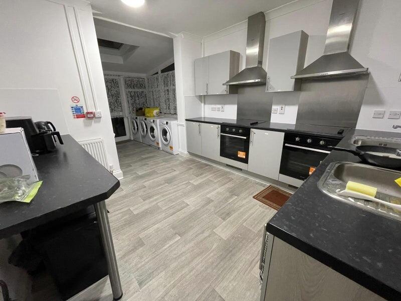 Modern shared kitchen with built-in ovens, stai...