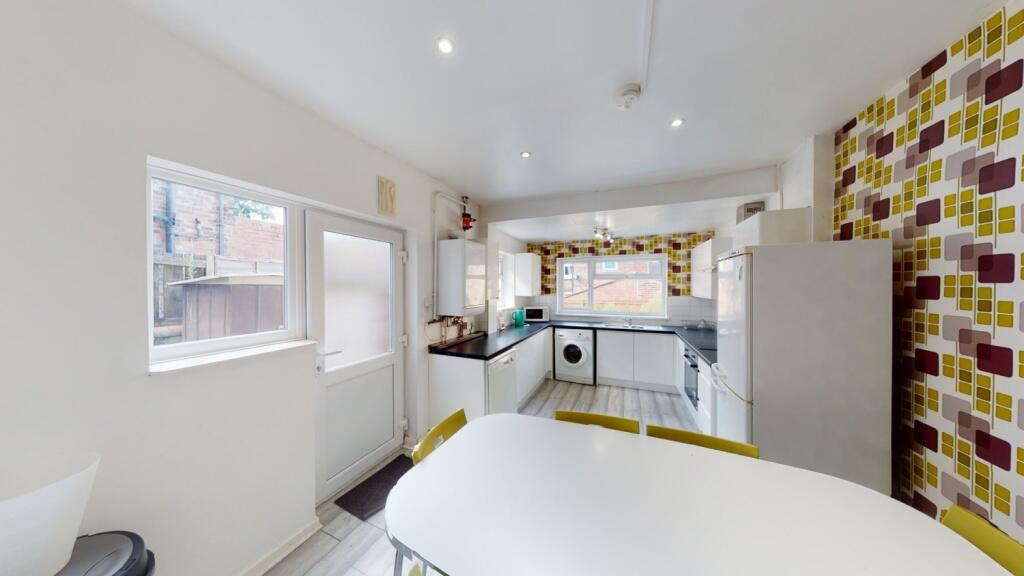 Bright and modern kitchen featuring clean white...