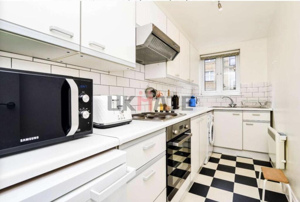 A bright and functional kitchen featuring white...