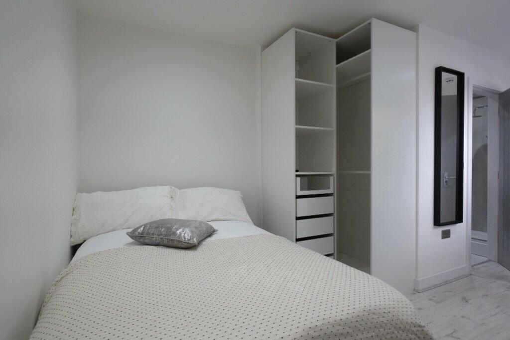 This inviting double bedroom features a cozy at...