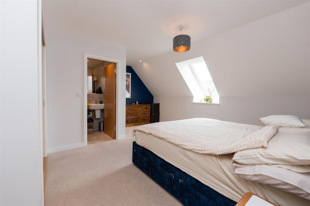 A bright and cozy master bedroom featuring a la...