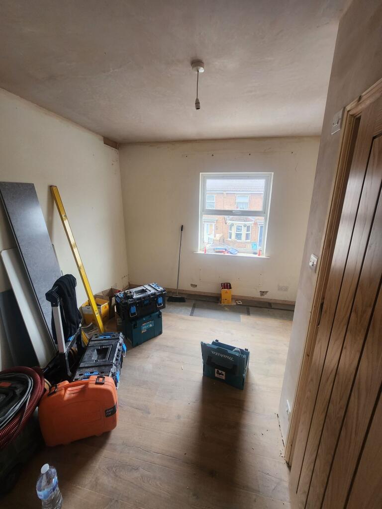 A small room with wooden flooring and a window ...