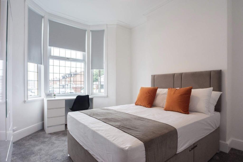 A bright and airy master bedroom featuring a co...