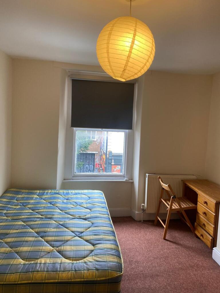 Cozy bedroom featuring a comfortable single bed...