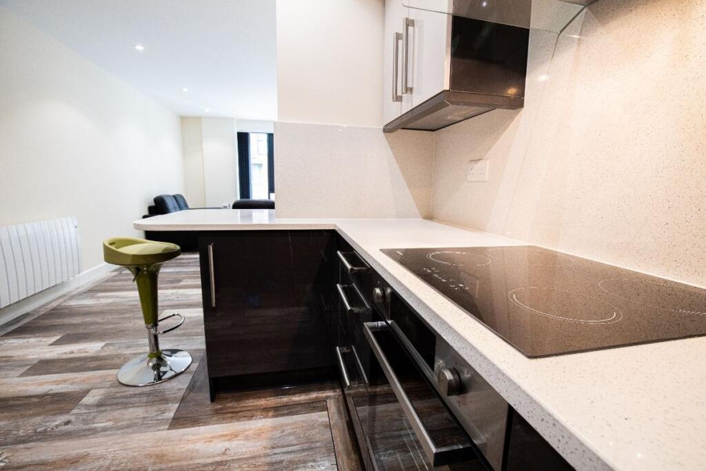 Modern kitchen space featuring sleek black cabi...