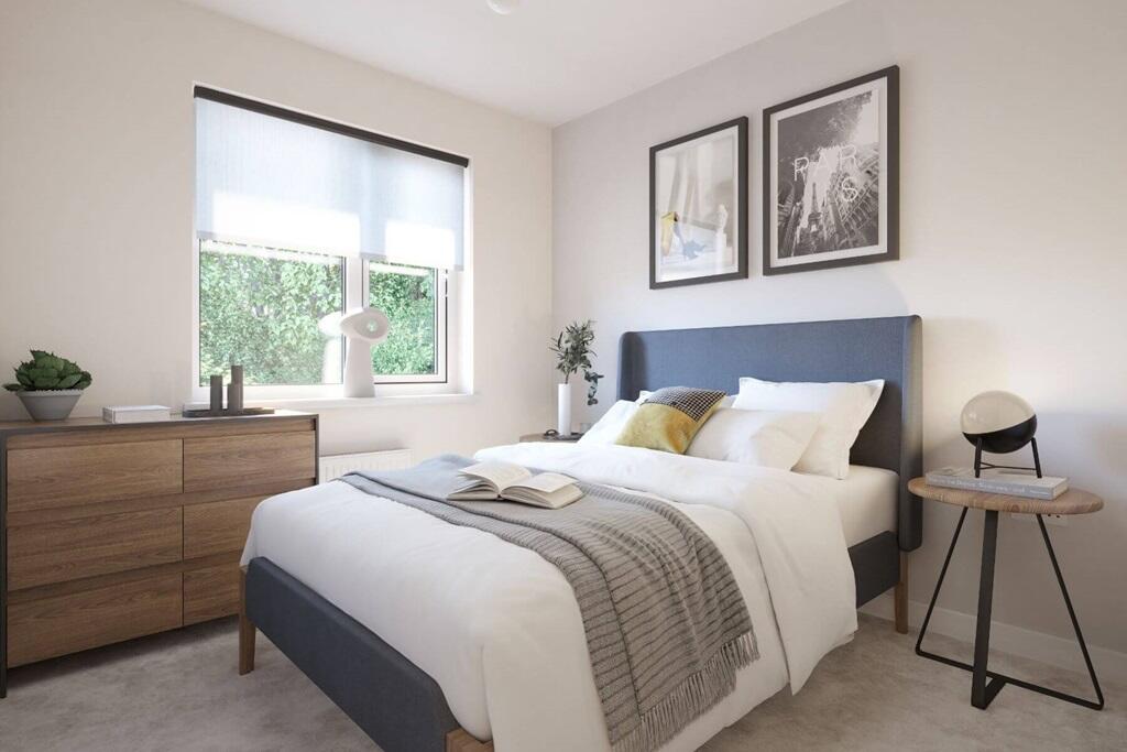 Bedroom 2 features a large window that fills the space with soft, natural light