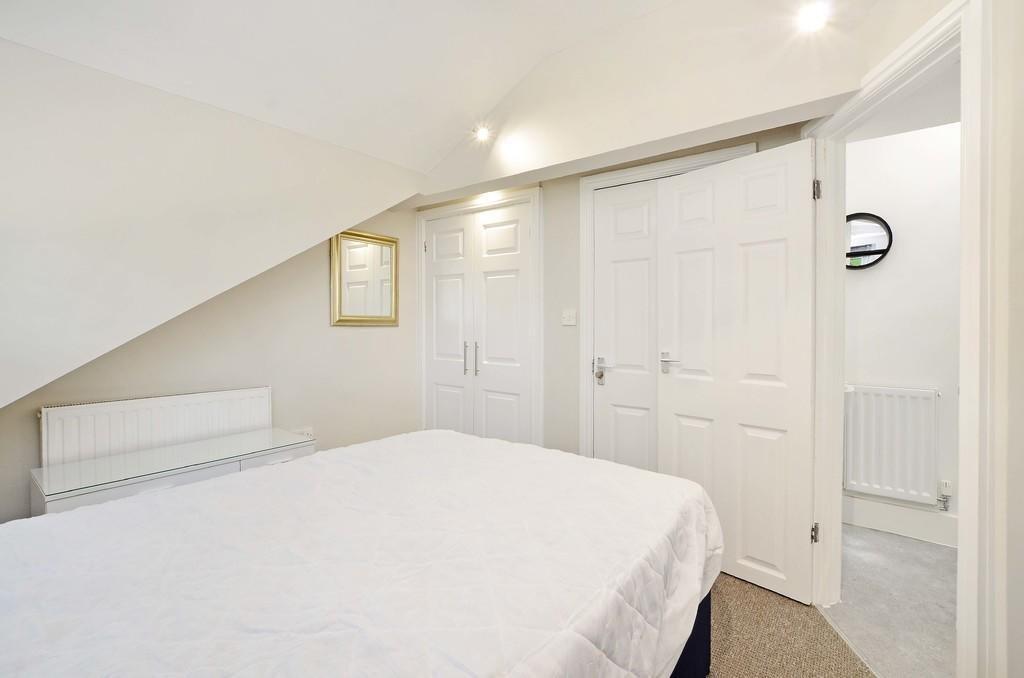 Bright and cozy master bedroom featuring a comf...