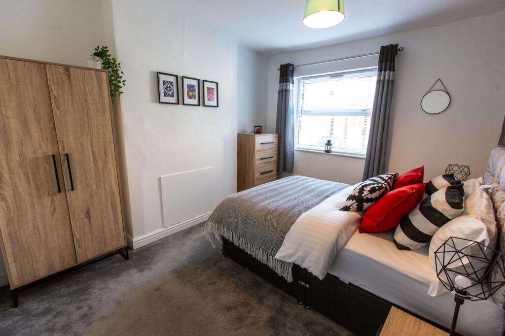 A clean and well-lit double bedroom featuring a...