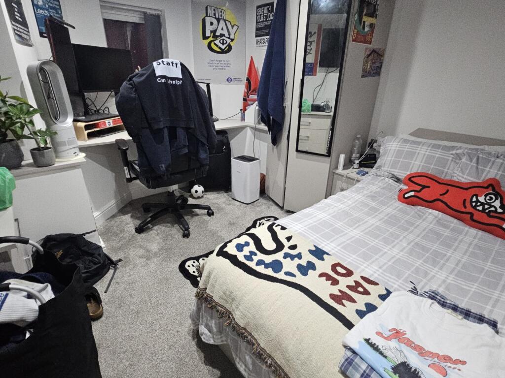 A cozy bedroom featuring a neatly made double b...