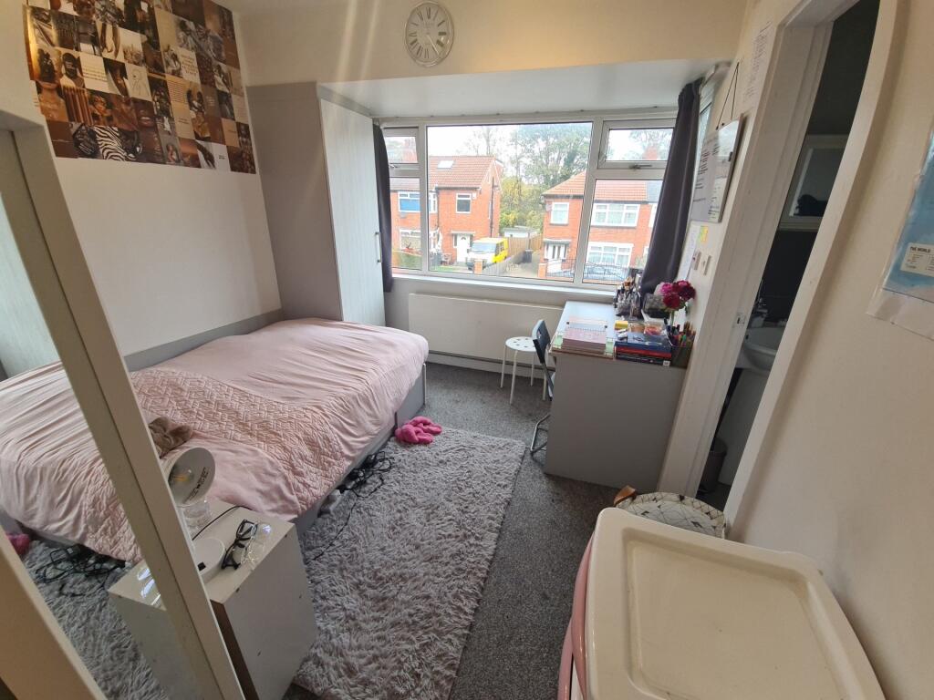 A cozy single bedroom featuring a comfortable b...