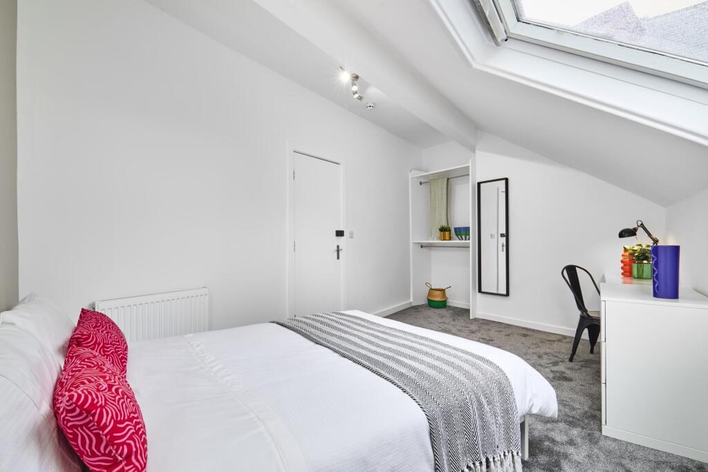 A bright and tidy bedroom featuring a comfortab...