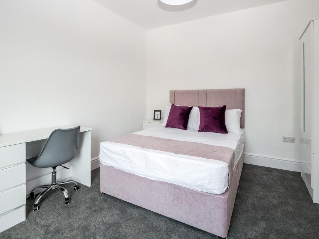 A bright and tidy double bedroom featuring a co...