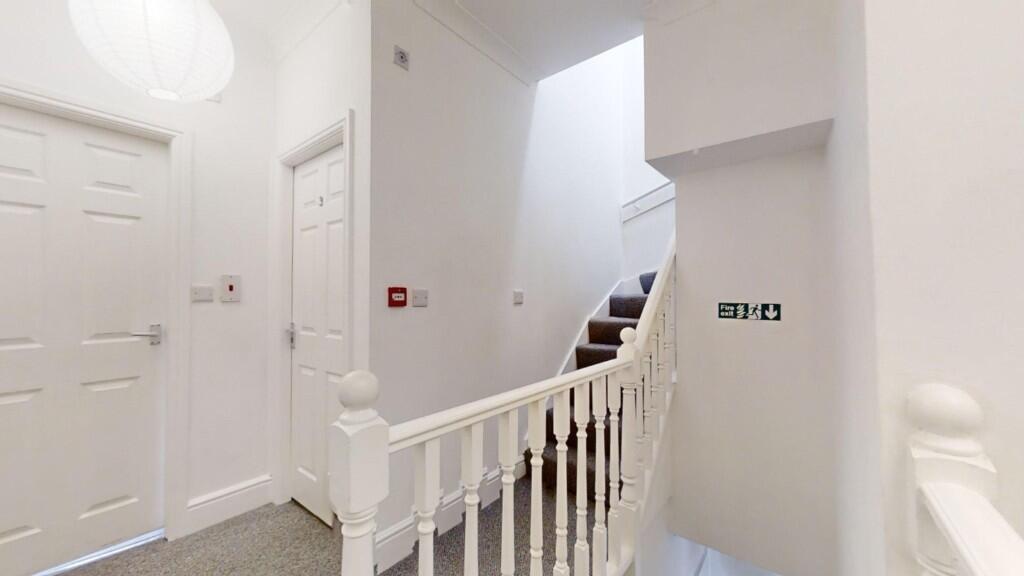 Bright and clean hallway with white walls and d...