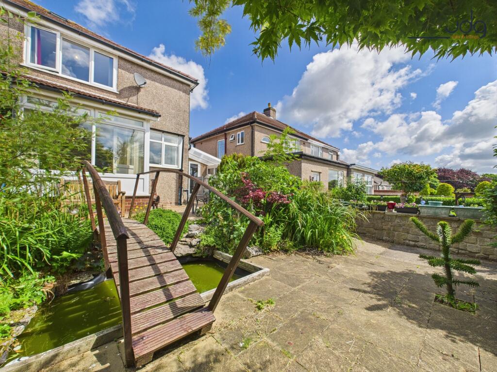South-facing rear garden with bridge and small pond