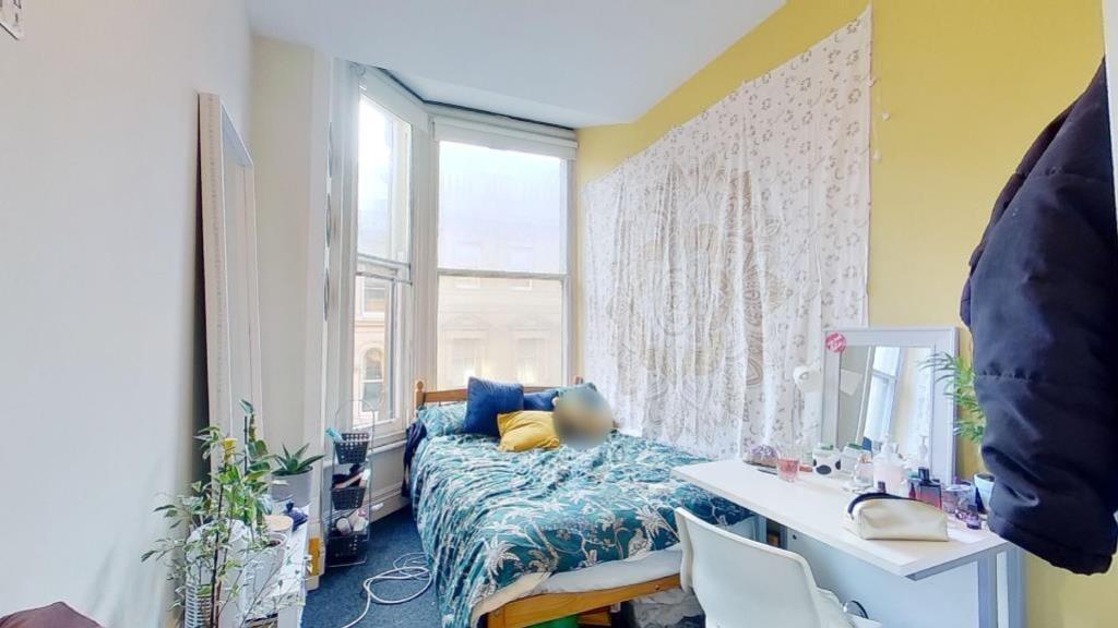 Bright and cozy bedroom featuring a large bay w...