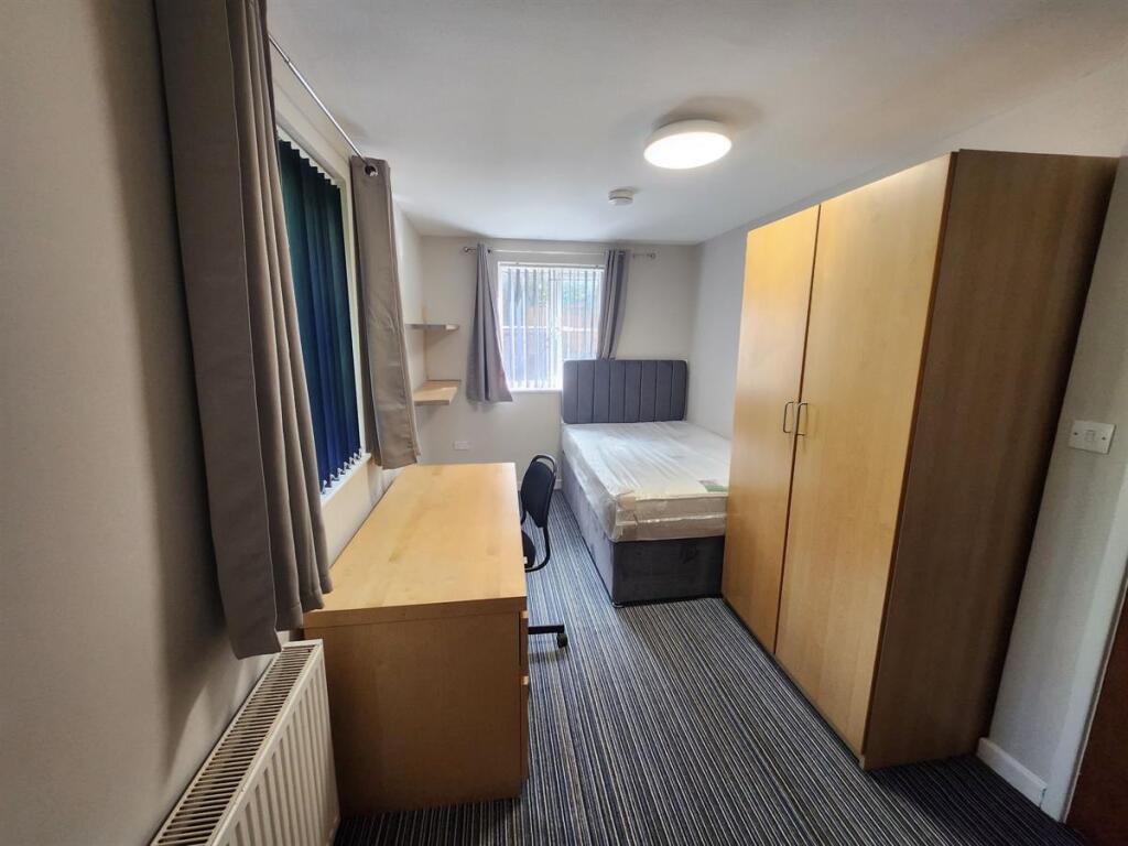 A small, tidy room featuring a basic single toi...