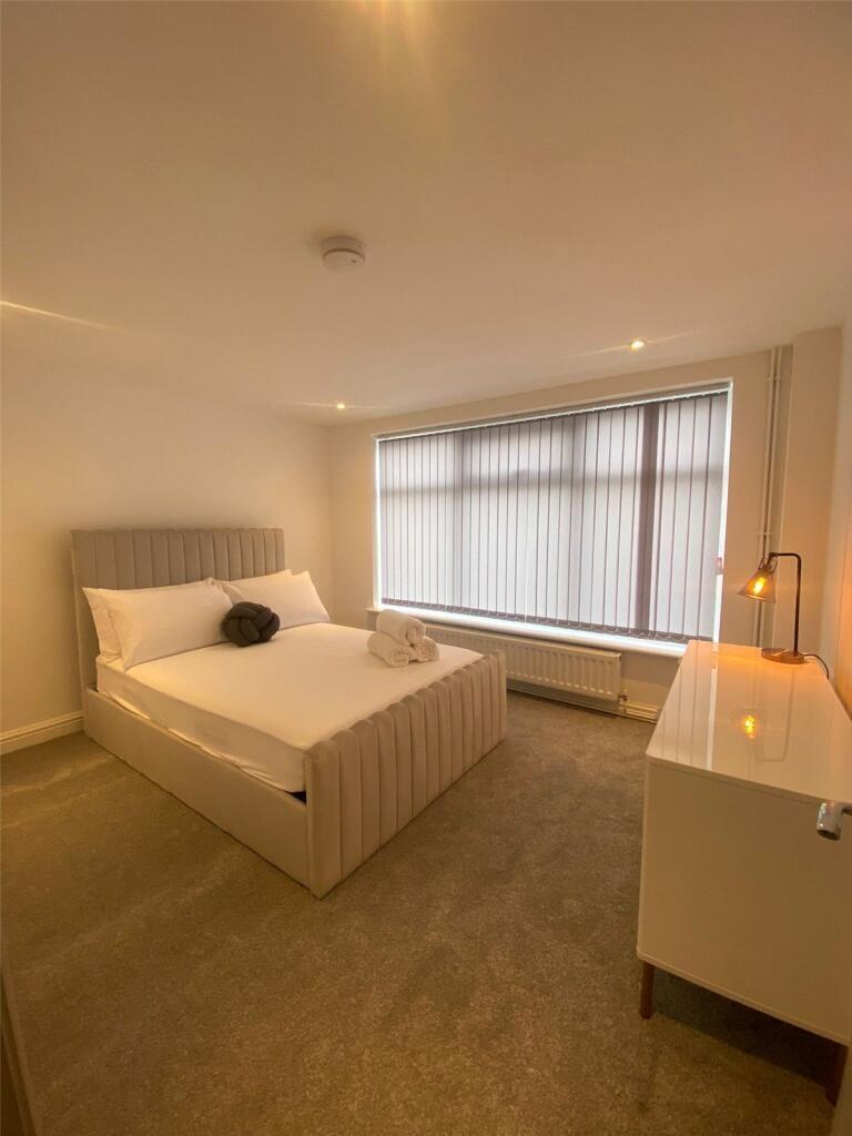 A modern, tidy bedroom featuring a comfortable ...