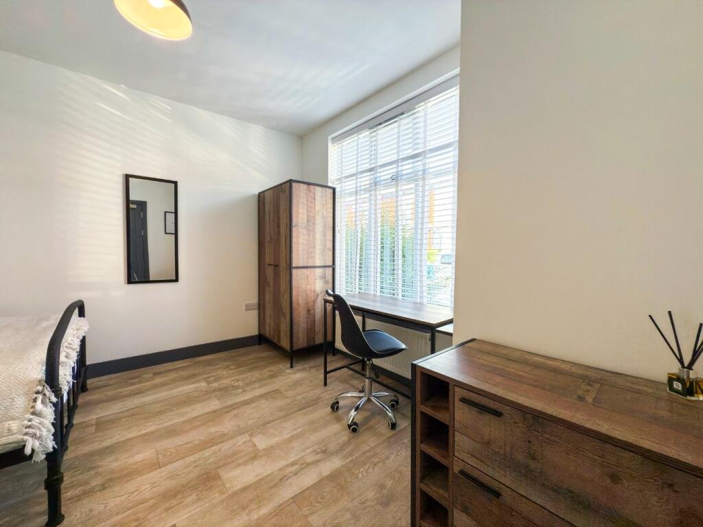 Bright, neatly presented bedroom with a large w...