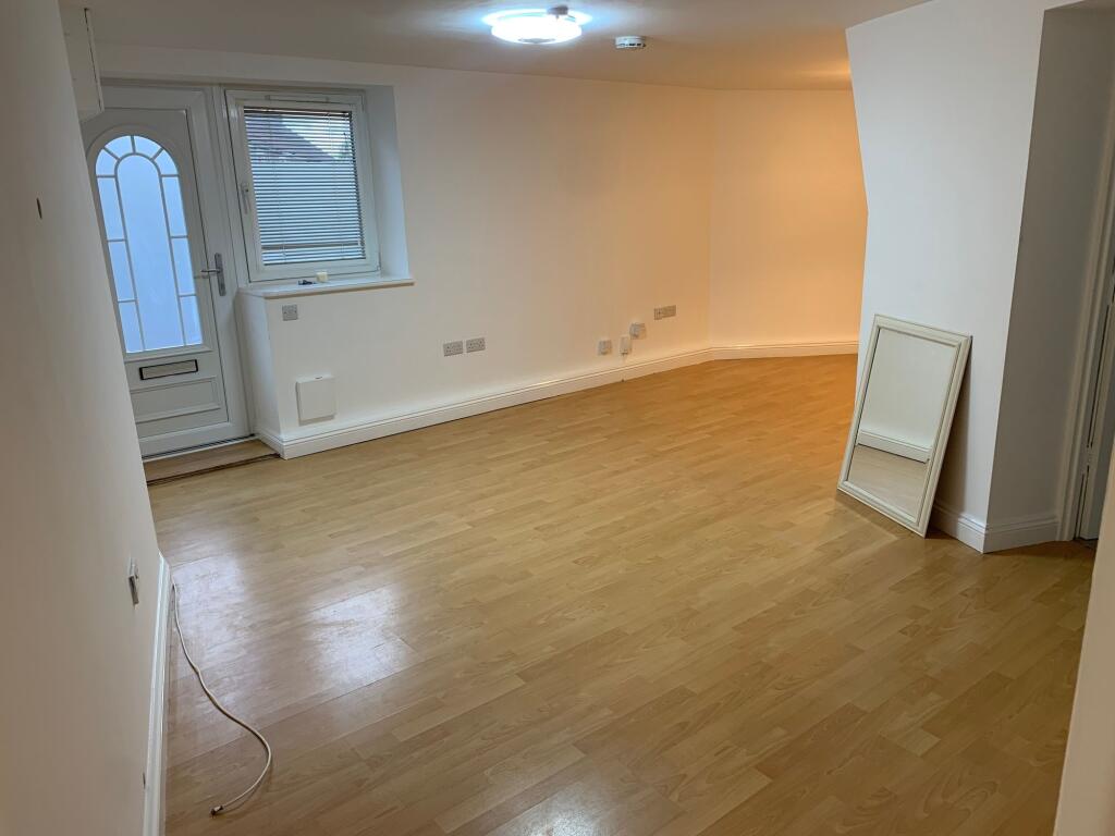 A spacious and clean living room featuring ligh...