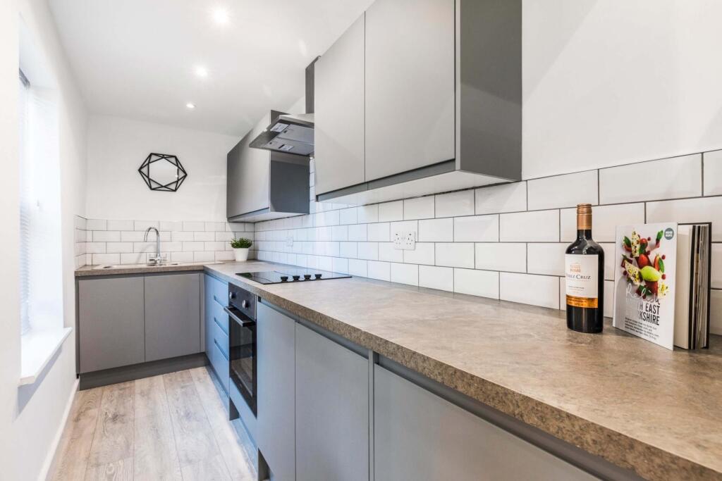 Modern fitted kitchen with grey cabinetry, long...