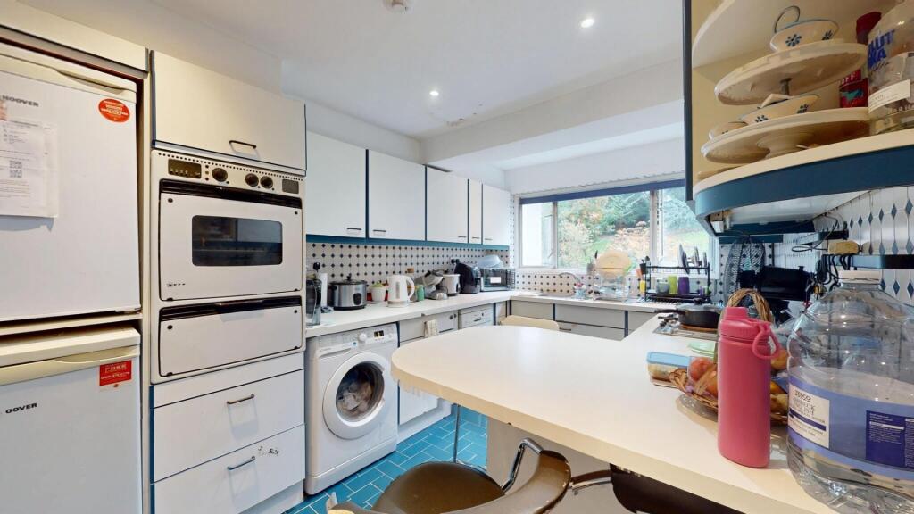 A bright and tidy kitchen with modern white cab...