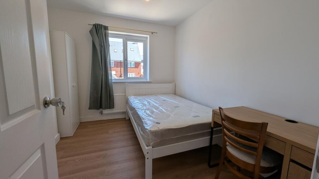Bright, simply furnished single bedroom with a ...