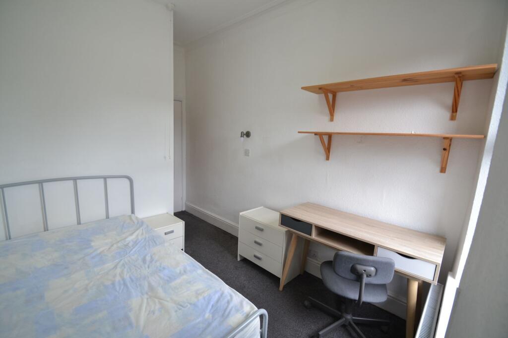 A neat single bedroom featuring a metal framed ...