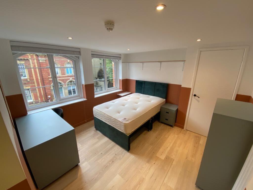 Spacious double bedroom featuring large windows...