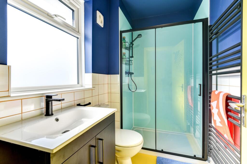 A modern bathroom featuring a sleek black vanit...