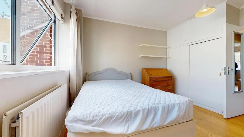 A bright double bedroom featuring a comfortable...