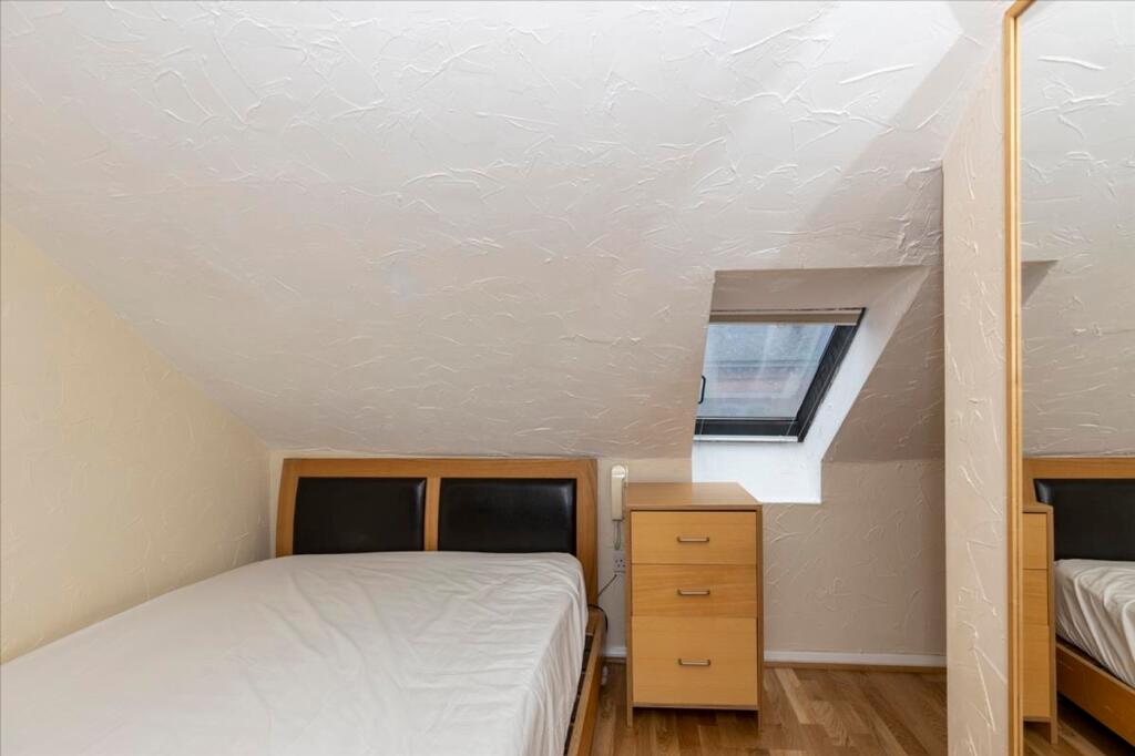 This cozy double bedroom features a comfortable...